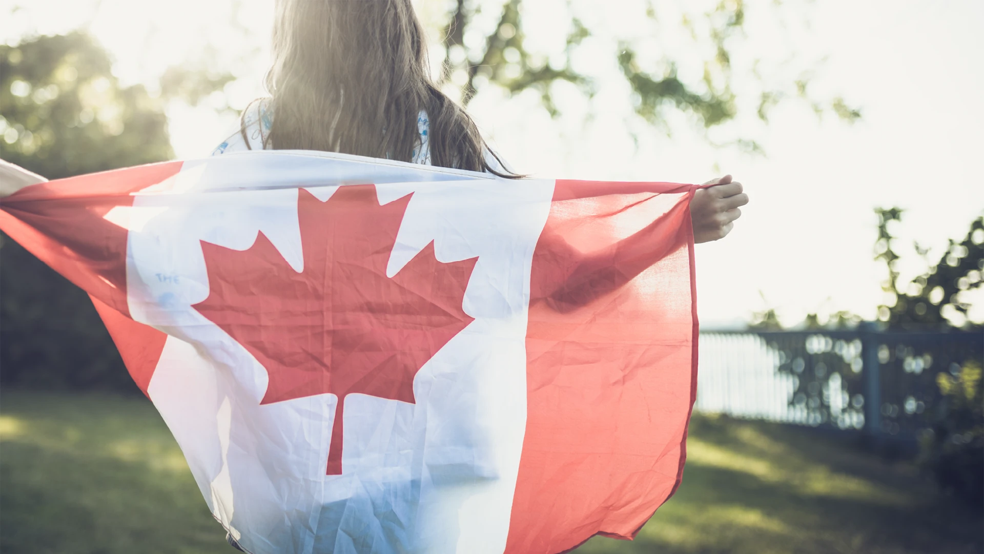 Girl holding a Canada flag as a cape